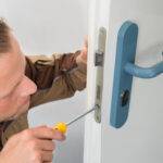 Portrait Young Male Carpenter Repairing Door Lock